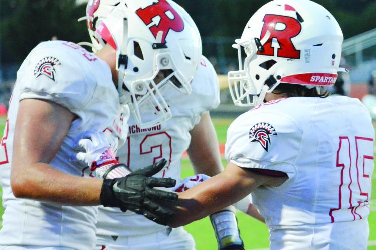 JOSH PYLE, No. 15, is congratulated by teammates Thomas Murphy, left, and Hunter Bowman after his interception Sept. 2 at Oak Grove. SHAWN RONEY | Staff