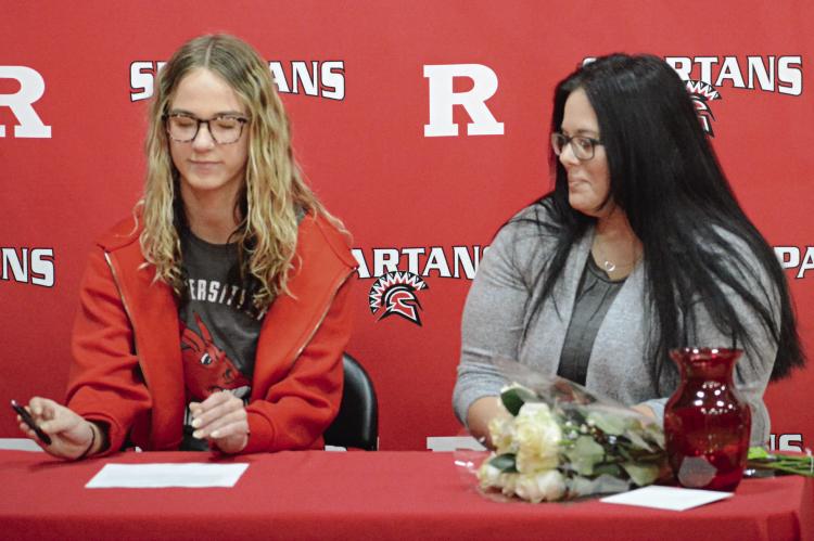 RICHMOND SENIOR Kaylee King (left) signs her letter of intent to study at and compete in women’s track and field for the University of Central Missouri in Warrensburg as her mother, Debbie Rosse, watches. Look for additional coverage April 11. SHAWN RONEY | Staff