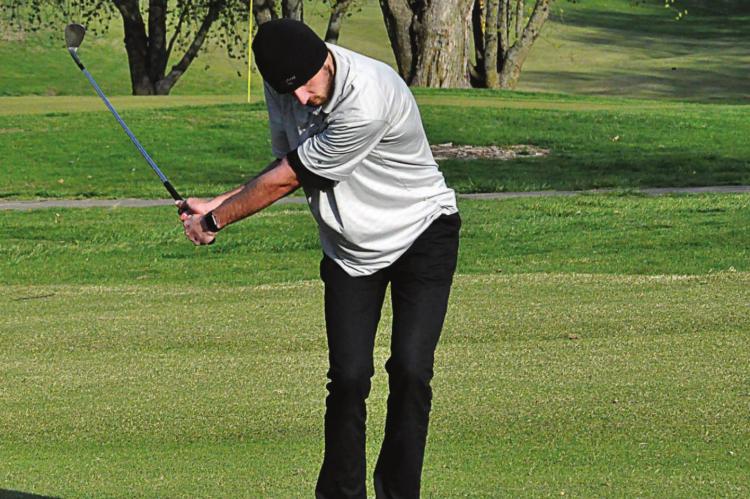 ORRICK SENIOR Dylan Comstock keeps his eye on the ball as he attempts an iron shot Monday at Shirkey Golf Course. SHAWN RONEY | Staff
