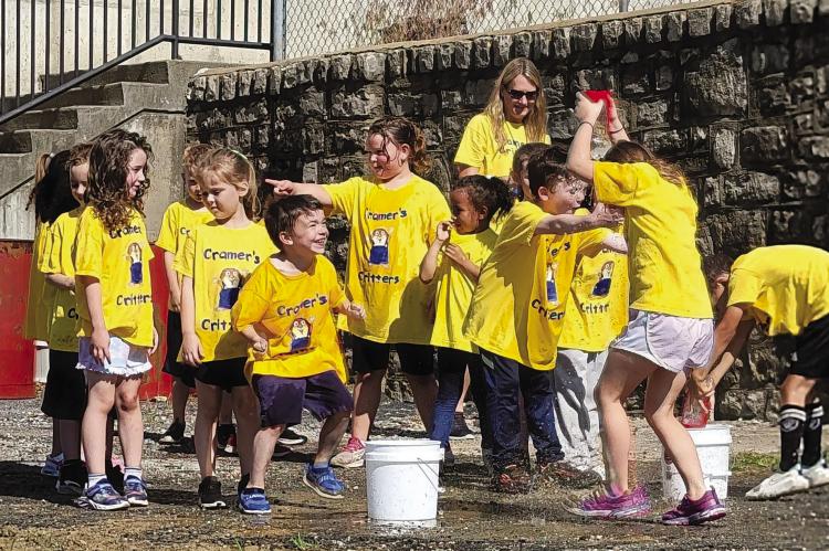 MRS. ASHLEY CRAMER’S class, named “Cramer’s Critters,” splash around during the water relay race. DIANA SHULL | Staff