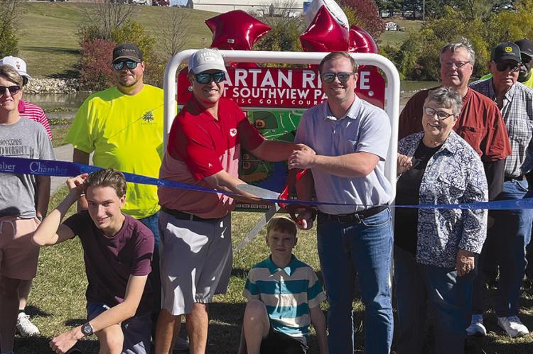 RICHMOND RESIDENT Dr. Ryan Lauck (center, left) and former Richmond City staffer James Gorham (center, right) cut the ribbon to celebrate the city’s Spartan Ridge at Southview Park disc golf course opening. Community leaders and members showed support for the event. The ribbon was provided by the Richmond Area Chamber of Commerce. SOPHIA BALES | Staff