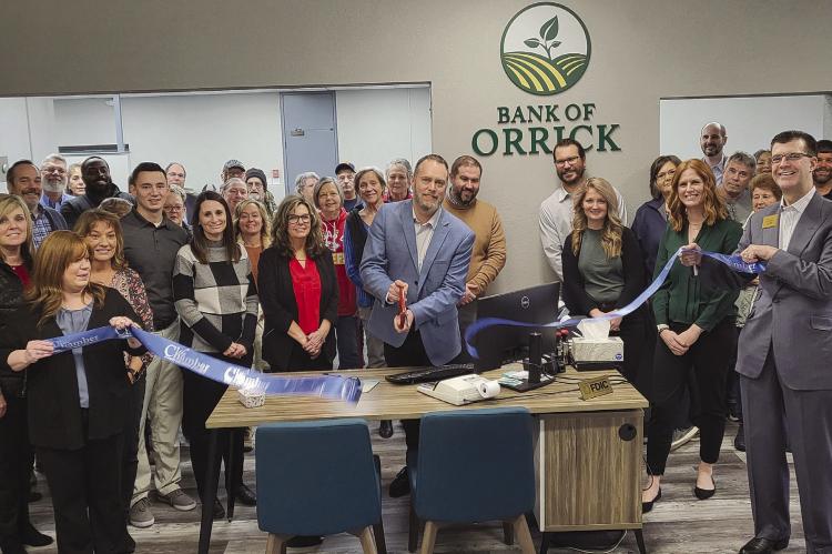 BANK OF ORRICK CEO/President Chris Bomheimer (middle) cuts ribbon during the reopening ceremony surrounded by the community and Richmond Area Chamber of Commerce members. SHARON DONAT | Staff