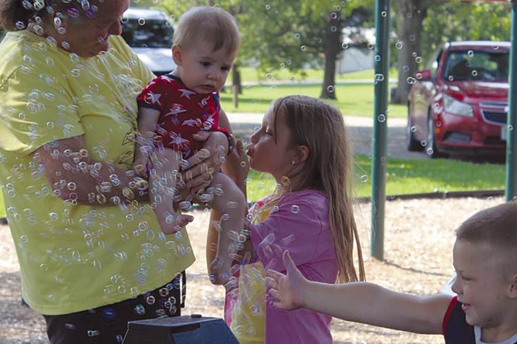 KELLY RARDON (from left), Stetson Basket, Journey Cameron and Hunter Williams enjoy the Bubbles in the Park event hosted by CAP. SHARON DONAT | Staff