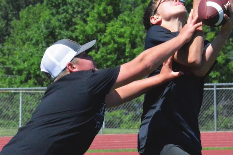 TRYCE McCOY, right, intercepts a pass June 2 at Spartan Stadium during a two-hand touch football scrimmage to help cap the Future Spartan Football Camp, offered to grades K-6. SHAWN RONEY | Staff