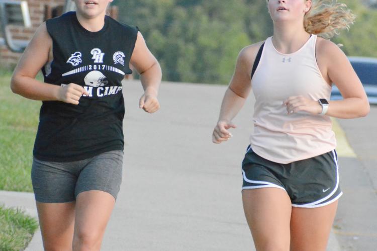 LIVIA CAVANAH, left, and Isabelle Dooley train for the Richmond High School cross country season – and to stay fit for cheerleading. SHAWN RONEY | Staff