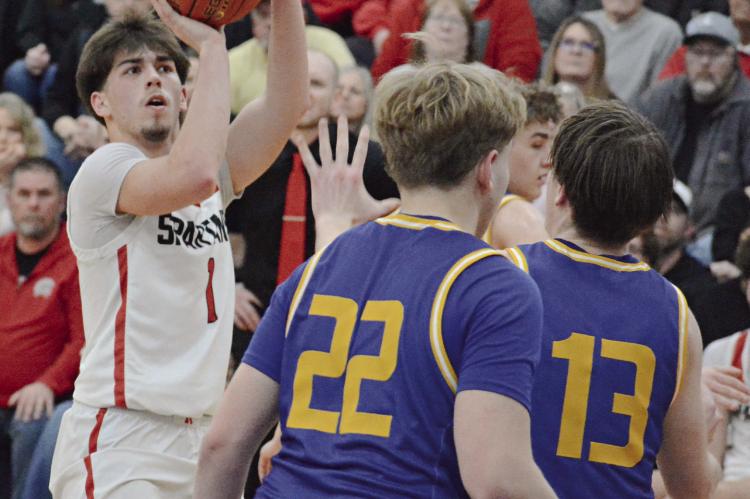 DRYDEN HENDRIX (left), a Richmond sophomore, looks to shoot over St. Pius X defenders Brady Stacy (center) and Matthew Schmitz. SHAWN RONEY | Staff