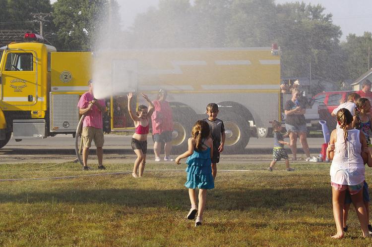 ORRICK FIRE DEPARTMENT volunteers spray children with hoses. MIRANDA JAMISON | Staff
