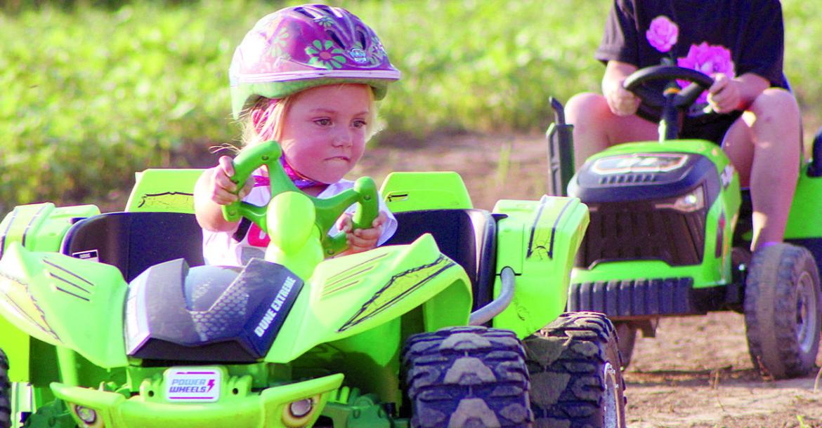 SHARON DONAT | Staff KAMERYN WILLIAMS races ahead of Kameryn Chowning during the first-ever Power Wheels racing event at the fairgrounds.