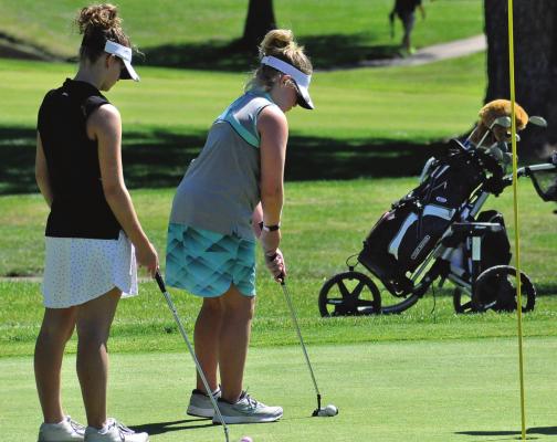 ISABELLE DOOLEY watches her kid sister, Karoline, putt as the girls play June 11 in their first-ever golf tournament. SHAWN RONEY | Staff