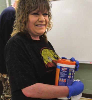 MAINTENANCE WORKER Rhonda Jones stands ready with approved disinfectant wipes.