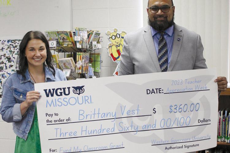 DEAR ELEMENTARY TECHNOLOGY Teacher Brittany Vest (left) is presented a $360 grant from Western Governor University (WGU) Midwest Regional Manager Daniel Avegalio, who says he loves supporting Missouri educators. SOPHIA BALES | Staff