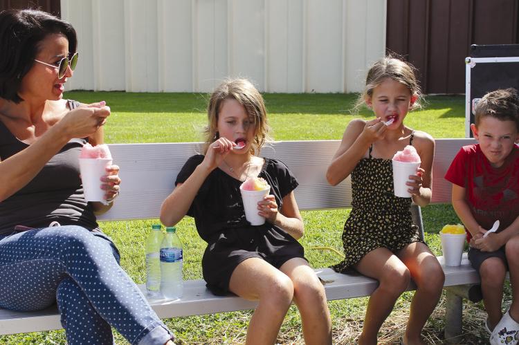 ANGELA, SUMMER, Minnie and Barrett Habermehl cool off with snow cones on the warm day. SOPHIA BALES | Staff