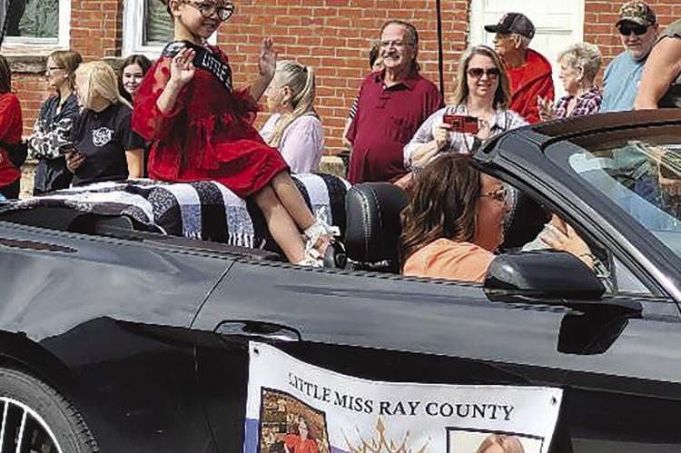 LITTLE MISS RAY COUNTY Charli Dunwoodie waves at the crowd during the Mushroom Festival parade. KAITLYN RIDDLE | Staff