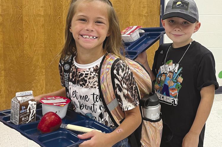 GRACIE HICKS (left) and William Woolfolk stand in the breakfast line on their first day back to Sunrise Elementary. SOPHIA BALES | Staff
