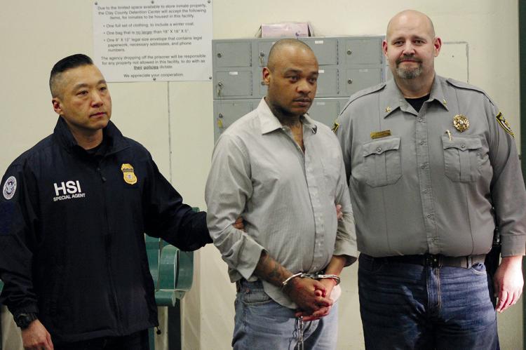 KANSAS CITY HOMELAND SECURITY INVESTIGATIONS Acting Special Agent in Charge Taekuk Cho (left) and Ray County Sheriff Scott Childers (right) escort escapee Justin Robinson into the Clay County Detention Center. SOPHIA BALES | Staff
