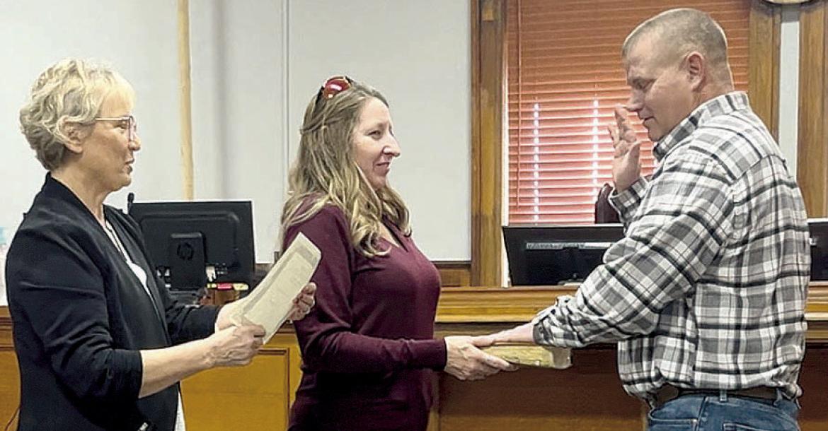 RETIRED RAY COUNTY CLERK Glenda Powell (left), administers the oath of office for Presiding Commissioner Billy Gaines (right), as his wife, Kathie, holds the bible. SOPHIA BALES | Staff