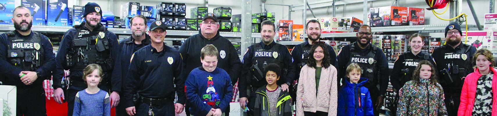 RICHMOND POLICE officers and the children they shopped with for the Shop with a Cop progrma stop for a group photo.