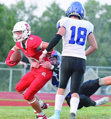 KEEPING THE FOOTBALL clutched with his right hand, Richmond’s Bryer Farnan fights through a tackle en route to a second-quarter catch-and-run touchdown during the Spartans’ Aug. 30 loss to visiting Harrisonville. SHAWN RONEY | Staff