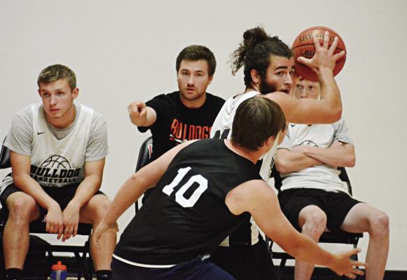 WITH TEAMMATES and a pointing coach (August Hoeper) behind him, Denver Douglas shields the ball and looks to pass Monday at the Barker Center. SHAWN RONEY | Staff