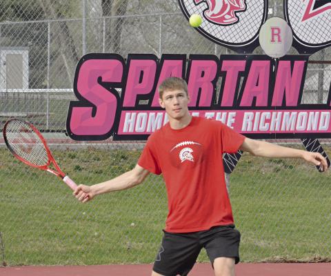 RICHMOND SENIOR Gabe Baker keeps his eyes on the tennis ball as he waits to hit a forehand shot during his singles match with Knob Noster’s Noah Schoepke Monday at Maurice Roberts Park. SHAWN RONEY | Staff