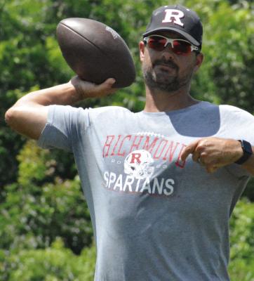 RICHMOND VARSITY COACH Nick Persell rears his arm back to throw as he leads his receivers and defensive backs through drills. SHAWN RONEY | Staff