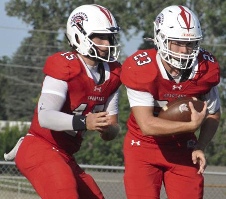QUARTERBACK JACOB LIEBERKNECHT (left) steps back as Bryson Pruitt carries the ball during Richmond’s annual Red and White Game. SHAWN RONEY | Staff