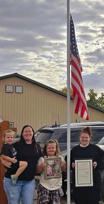 THE FAMILY OF FALLEN deputy Jeff Perkins is on hand to witness the flag being lowered to halfmast in his honor. Submitted