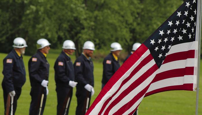 SHARON DONAT | Staff AN AMERICAN FLAG waves in front of the honor guard as the ceremony begins.