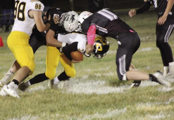 CALLED ON to fill the void left on offense by an injured Jaxon Miller, Orrick senior Zander Stevinson, No. 3, finds himself sandwiched between two Aggies while carrying the football Oct. 7 at Norborne. SOPHIA BALES | Staff