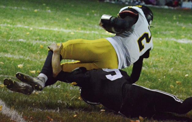 BRODY FIFER (bottom) lunges and brings down Orrick’s Gage Tebbe for a touchdown-saving tackle during the first quarter of Norborne Hardin-Central’s District 4 win over the Bearcats. SHAWN RONEY | Staff