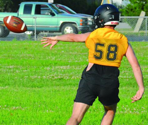 XAVIOR GASKINS pitches the ball back during one of his reps at quarterback on Orrick’s first day of varsity eight-man football team camp. SHAWN RONEY | Staff