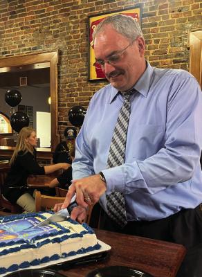 FORMER PUBLISHER of the Richmond News and Excelsior Springs Standard Brian Rice cuts his retirement cake. Rice has begun a new journey as president of the Excelsior Springs Area Chamber of Commerce. SOPHIA BALES | Staff