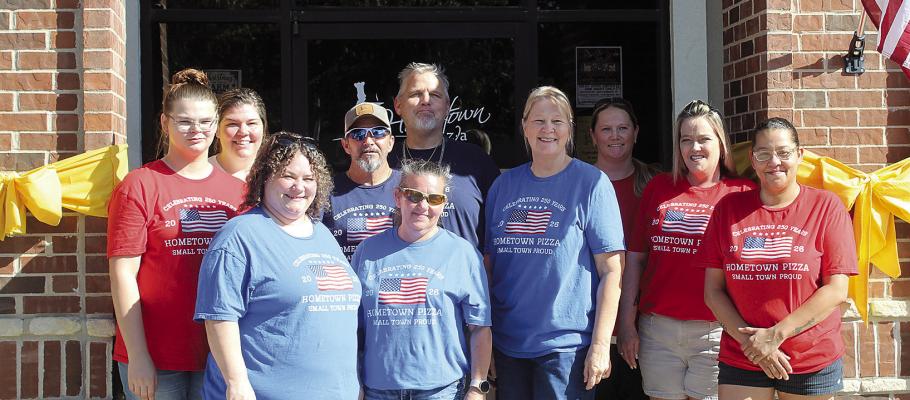 HOMETOWN PIZZA STAFF wear specially made shirts and decorate the restaurant in support of Ryan Higgins, who was recently deployed to the Middle East. Higgins’ mother, Lynn (second from right), and other staff members encourage community members who want to support Ryan and those serving with him to drop off cards or care packages at Hometown Pizza. SHARON DONAT | Staff