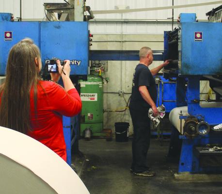 RICHMOND NEWS AND Excelsior Springs Standard Pressman Danny Shull checks ink distribution while journalism teacher Katherine Rold captures the process for her students. SHARON DONAT | Staff