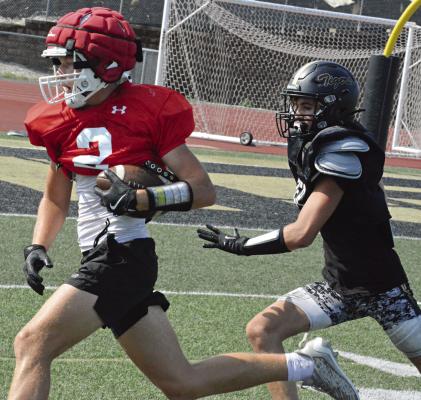 HOLDING THE FOOTBALL firmly with his left arm, Richmond wide receiver Bryer Farnan pulls away on a catch-andrun play recently during a scrimmage rep with Excelsior Springs at Tiger Stadium. SHAWN RONEY | Staff