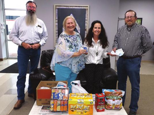 AT THE EXCHANGE of donation items and cash are, from left, Pastor Art Endsley, Barbara Britt, Michele Orpin of the Veterans Community Project and Tim O’Dell.
