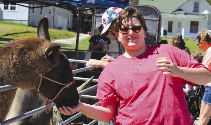 KARCYN ROOT-GAINES feeds the llama at the petting zoo during the Community Emergency preparedness event.