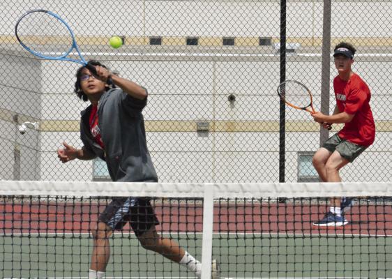 DARIUS MAYLON of Richmond (left) looks to hit a volley at the net in districts, with doubles partner Jazspher Ulleberg watching from behind the baseline. SHAWN RONEY | Staff