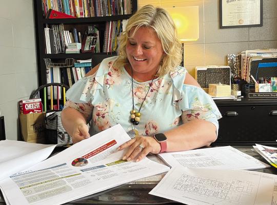 DR. MARLAINE BOYD, principal of Dear Elementary, looks through the blueprints of the upcoming Richmond Early Childhood Center. SOPHIA BALES | Staff