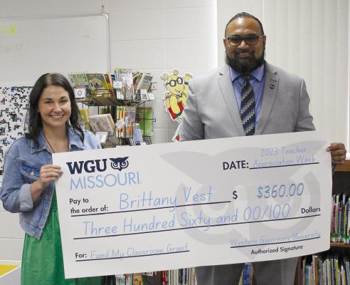 DEAR ELEMENTARY TECHNOLOGY Teacher Brittany Vest (left) is presented a $360 grant from Western Governor University (WGU) Midwest Regional Manager Daniel Avegalio, who says he loves supporting Missouri educators. SOPHIA BALES | Staff