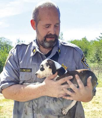 RAY COUNTY Sheriff Scott Childers holds his new puppy on Aug. 13 from a hoarding house in Rayville. The puppy, named “Presley,” is one of 70 dogs found that day and is a hit with Childers’ son, according to the sheriff. SUBMITTED