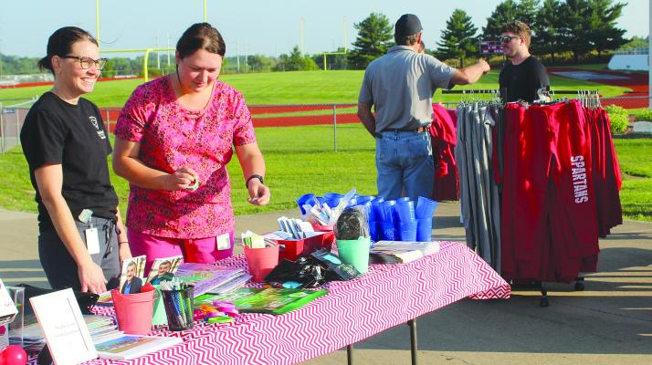 SHARON DONAT | Staff LPN SARAH KILPATRICK (left) and Public Health Educator Madilyn Stevenson prepare information from the Ray County Health Department.