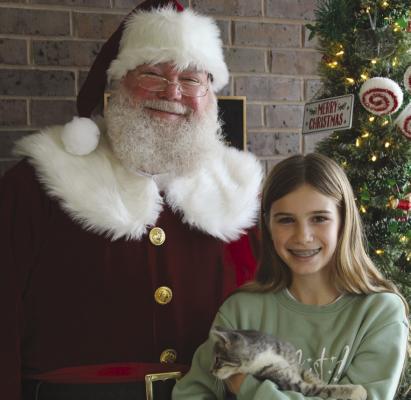 WHILE VISITING Ray County Humane Society, Santa wishes Lilo the kitten Christmas blessings at her new home with Kennedy Beal. SHARON DONAT | Staff