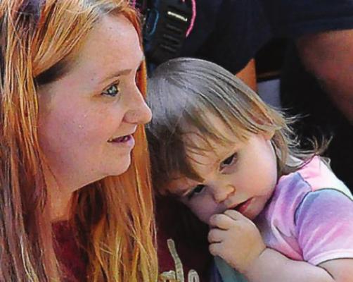 CAYENNE STARK holds her daughter, Gabriella, 2, at a drive-by party. SHAWN RONEY | Staff