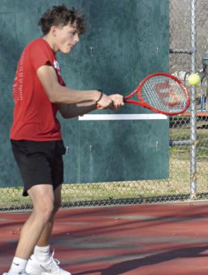 SHAWN RONEY | Staff JAXON AHART attempts a double-fisted backhand during a preseason practice. Ahart is the lone freshman on Richmond’s varsity boys tennis roster, Missouri State High School Activities Association information states.