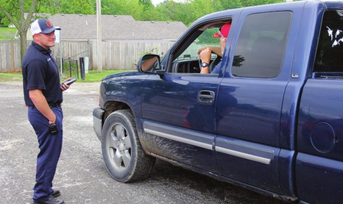 RICHMOND firefighter Cody Oliphant talks with Jerry McGraw while waiting for 15 minutes to pass after McGraw receives a COVID-19 shot on May 19 at the Ray County Fairgrounds.