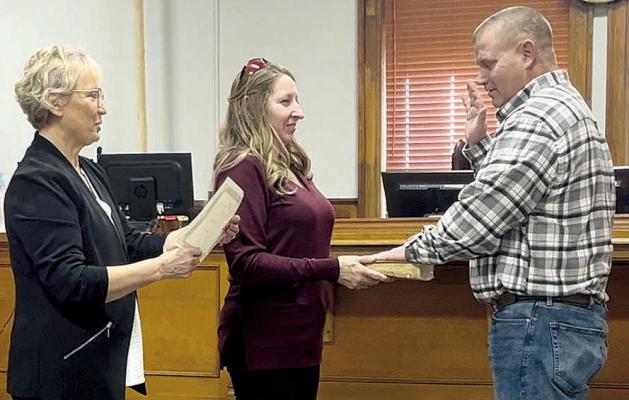RETIRED RAY COUNTY CLERK Glenda Powell (left), administers the oath of office for Presiding Commissioner Billy Gaines (right), as his wife, Kathie, holds the bible. SOPHIA BALES | Staff