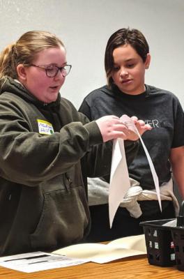 FROM THE FOLDER, Madison Wolf and Arielle Snyder pick paperwork.