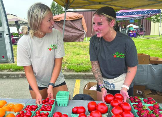 SOPHIA BALES | Staff Wellington residents Alison Dehn (left) and Sydney Rukavina converse as they prepare to sell fruit and vegetables at the Summer Bash and Market. See story on page 5.