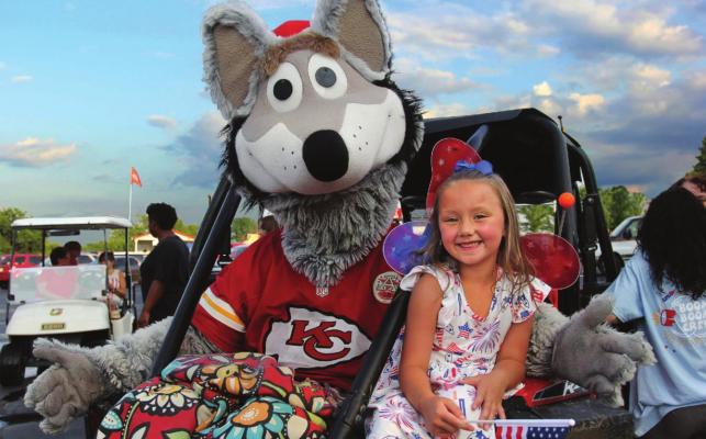 THE RICHMOND American Celebration Children's Parade grand marshal Kansas City Chiefs mascot KC Wolf, hitches a ride with Oaklee Cloninger, 6.